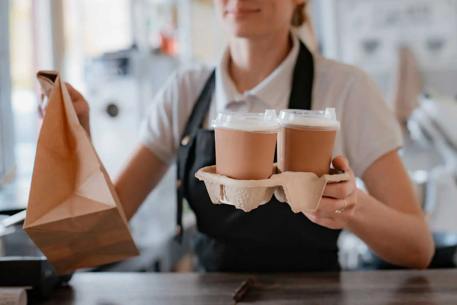 barista handing coffee to customer