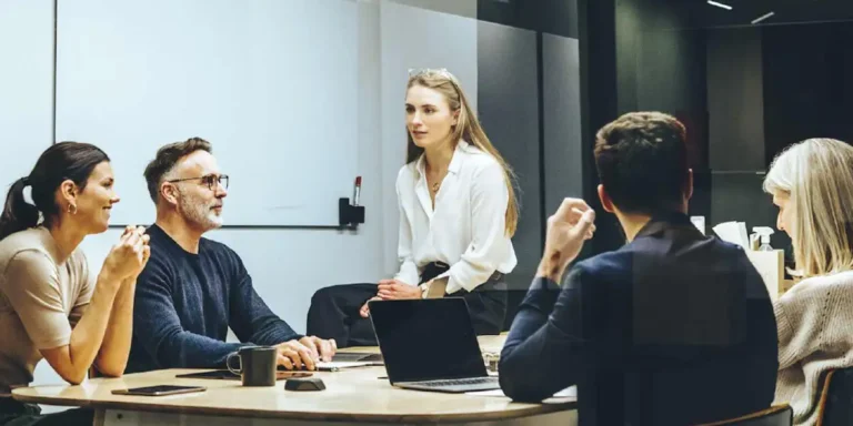 woman speaking with colleagues in a conference room