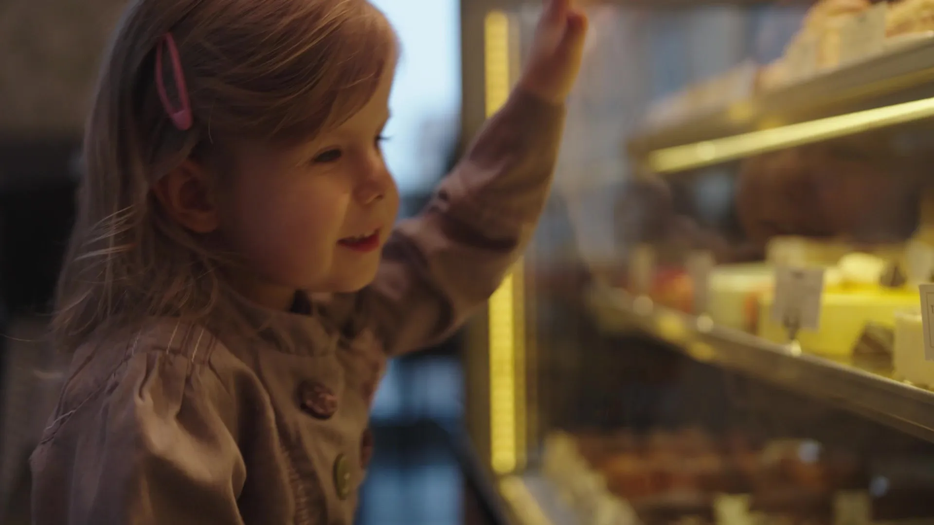 girl looking at cake in a bakery